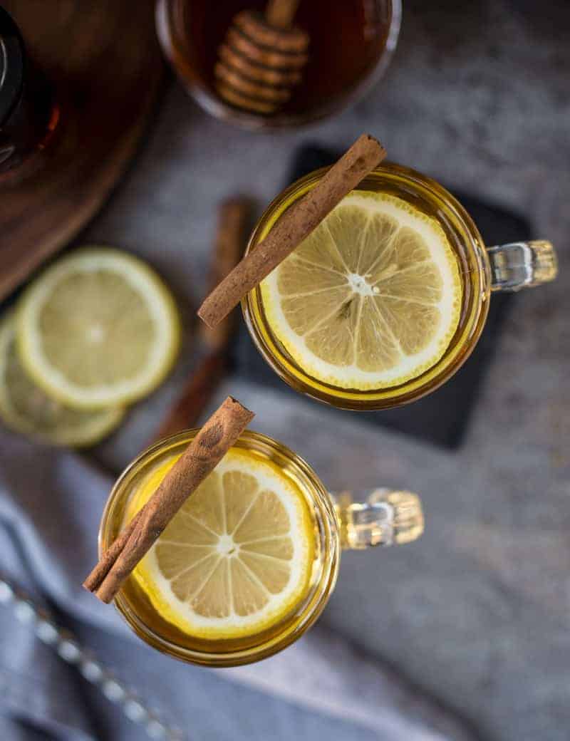 Hot Toddy in glasses with lemon and cinnamon sticks.
