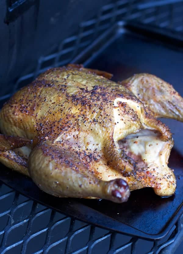 Whole roaster chicken being cooked on a smoker