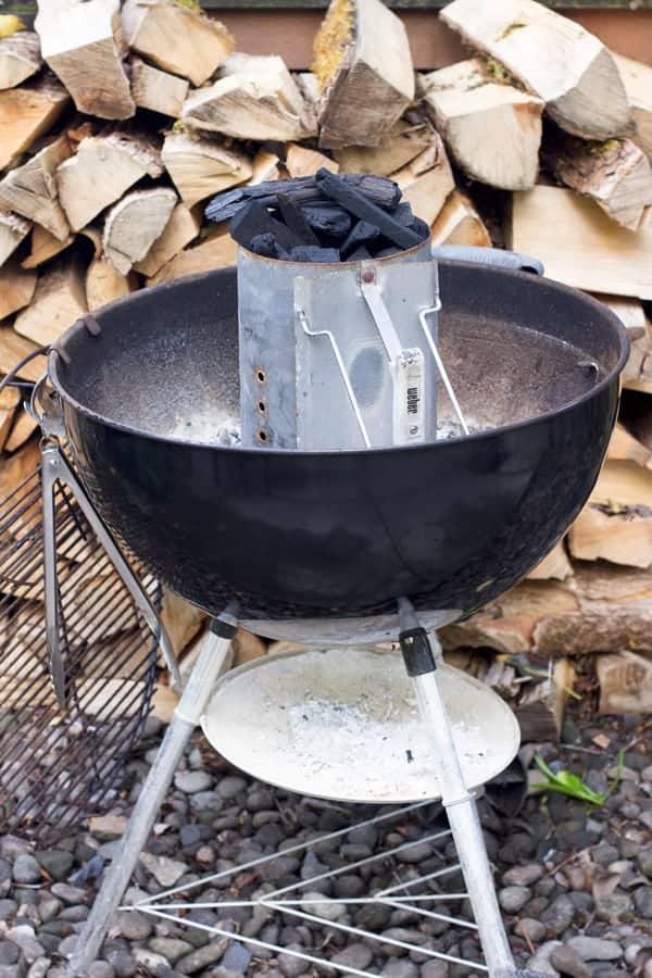 A charcoal chimney started in a kettle grill is a basic step in learning how to grill.