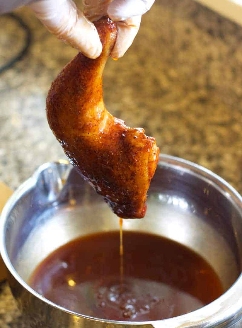 Dipping chicken pieces in a Carolina BBQ Sauce