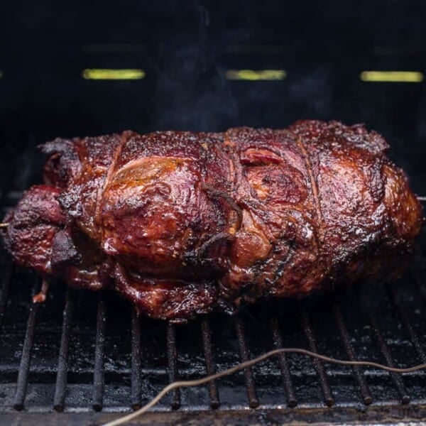 A smoked lamb shoulder cooking on the grill