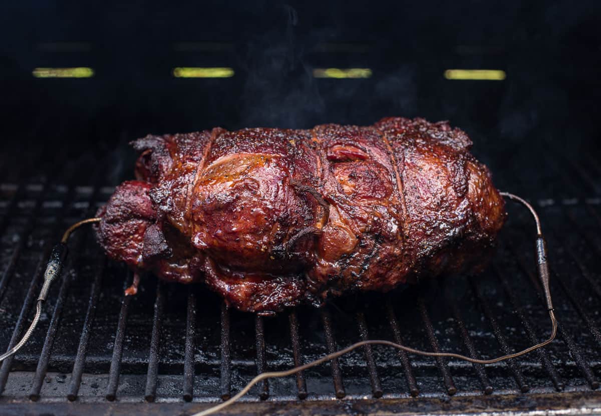 A smoked lamb shoulder cooking on a pellet grill