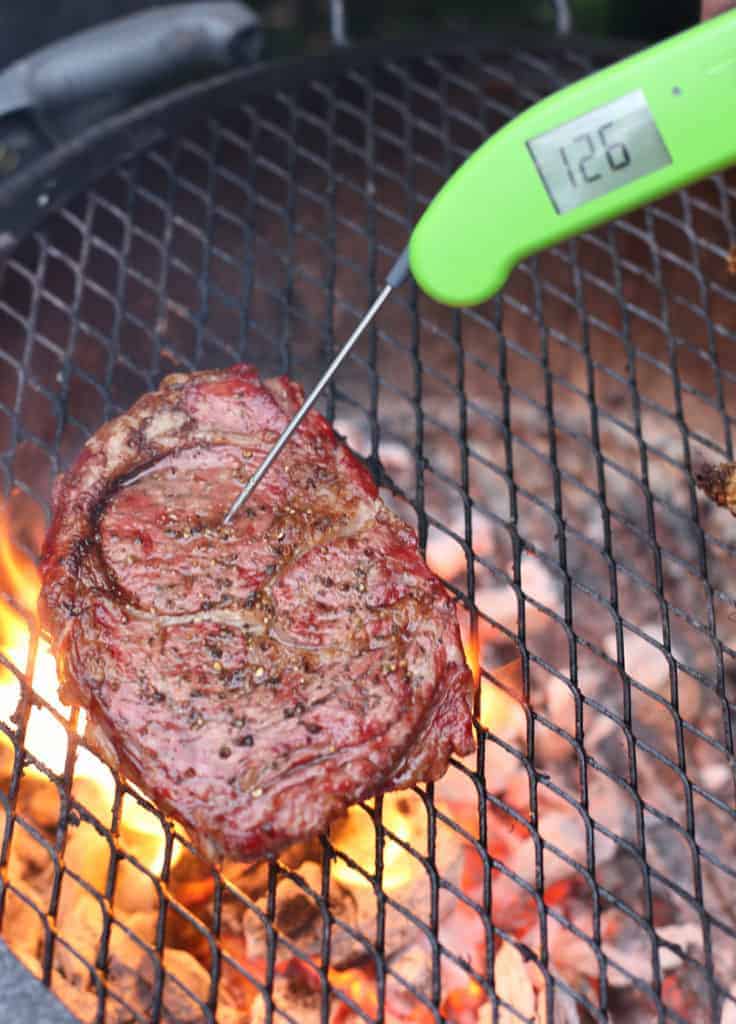 A ribeye on the grill using reverse sear method, temperature being taken with a Thermapen