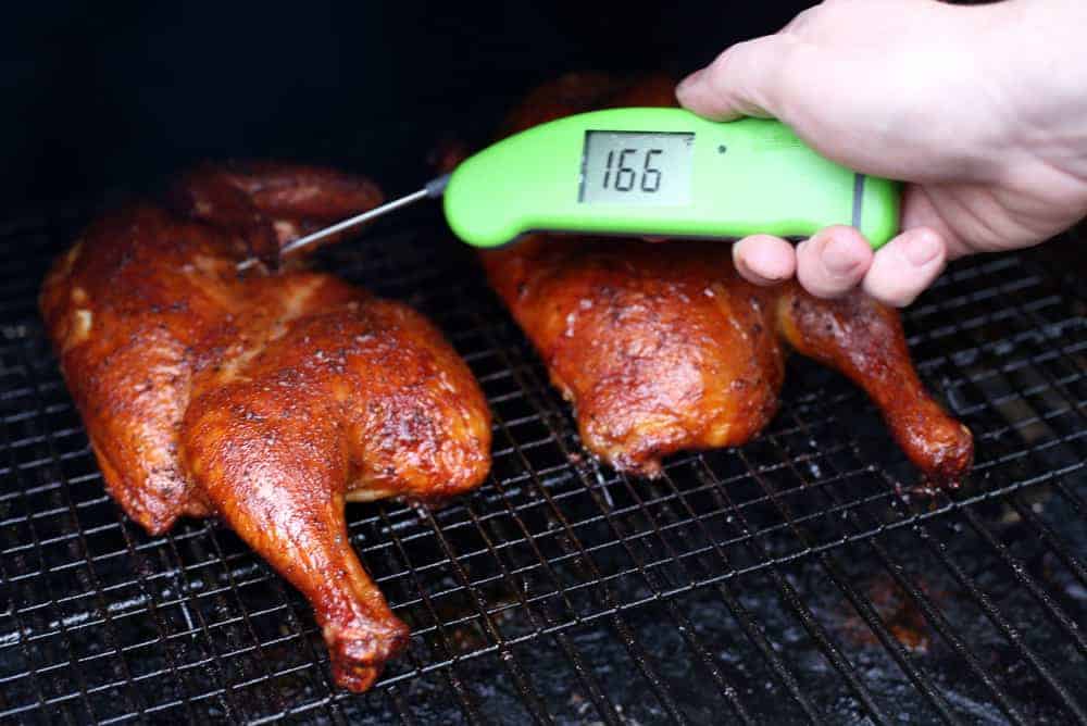 Taking temperature of smoked chicken with a digital thermometer 