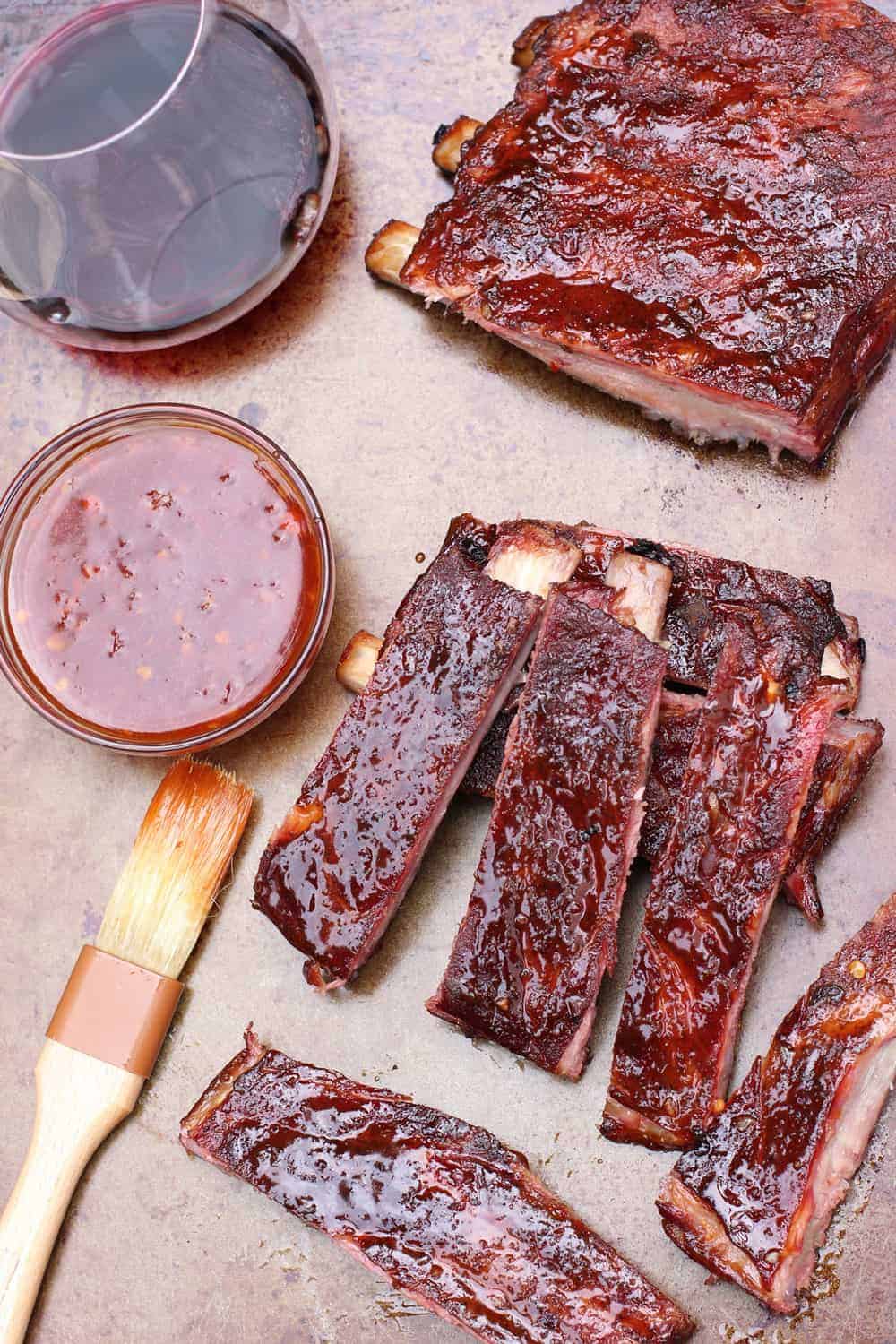 Asian rack of ribs and sauce on platter.