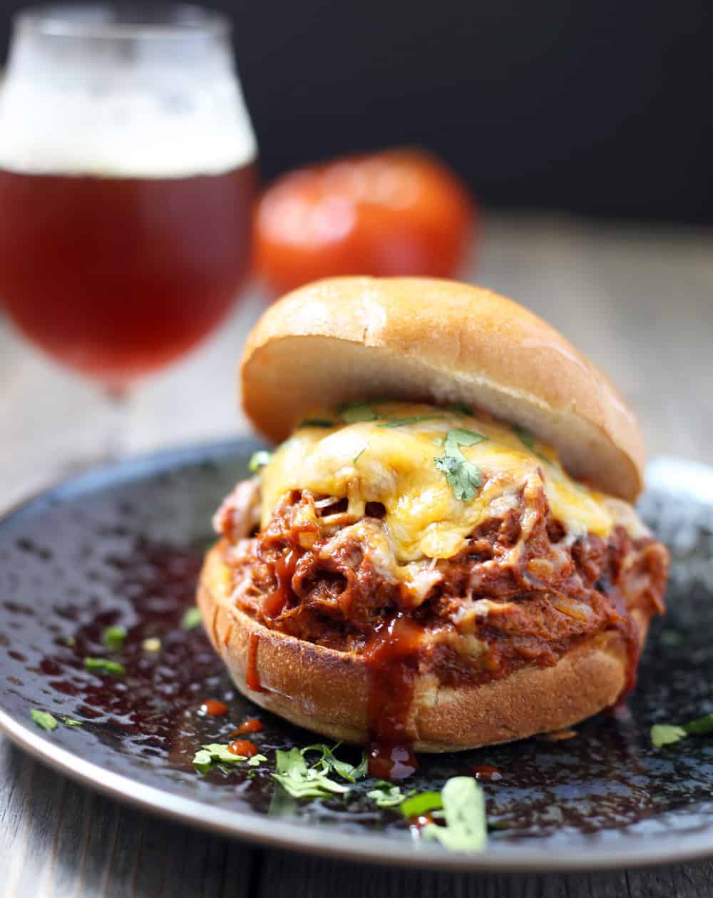 pulled pork sloppy joe sandwich topped with cheese and cilantro