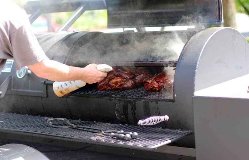 Spritzing meat on a smoker