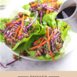 Lettuce wraps full of smoked pulled pork, carrots and cabbage with a homemade soy sauce over top