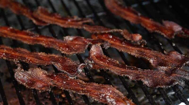 Crispy Smoked Bacon cooking on a smoker