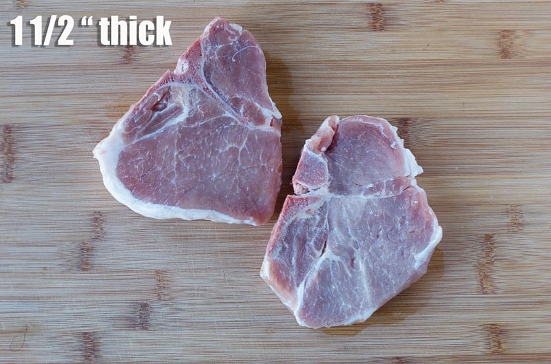 Two raw pork steaks on a cutting board