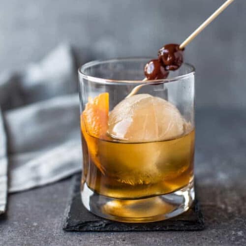 Round cube of smoked ice in a glass with an old fashioned