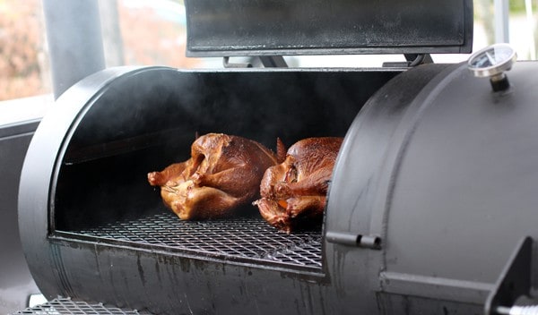 Two turkeys cooking on a smoker
