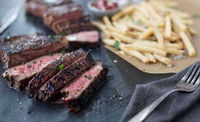 Sliced Coffee rubbed steak with fries.