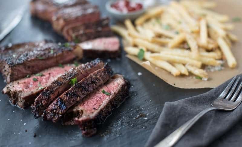 Recipe for Grilled Coffee Dry Rubbed NY Strip Steak. Easy and delicious New York Strip Steaks, marinaded in a coffee and wine mix and grilled to perfection. Sliced Coffee rubbed steak with fries.