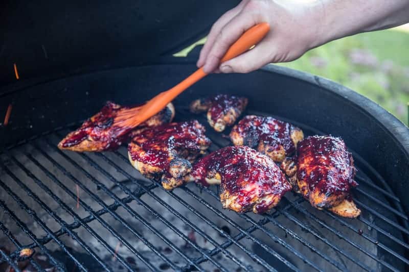 Glazing chicken on a grill