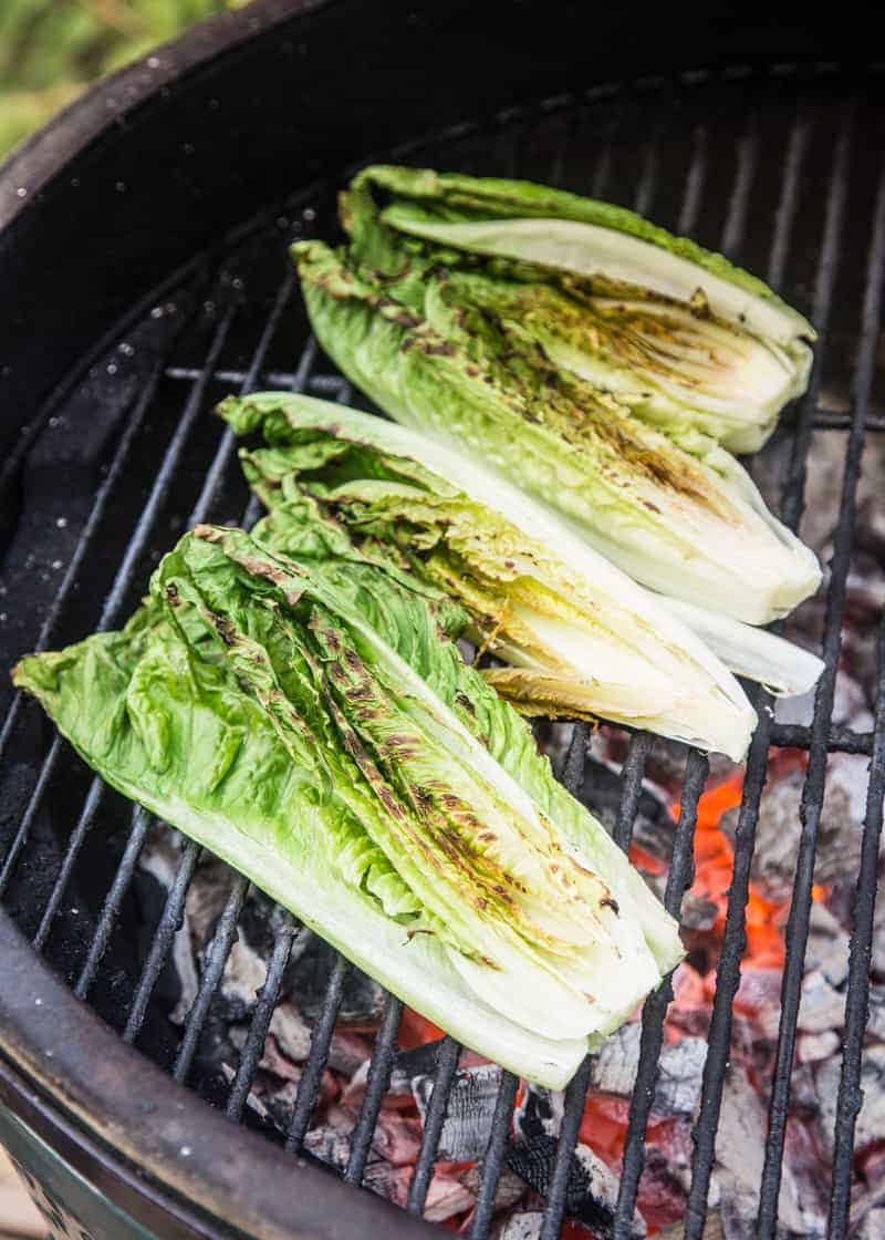 Romaine lettuce grilling over a charcoal grill