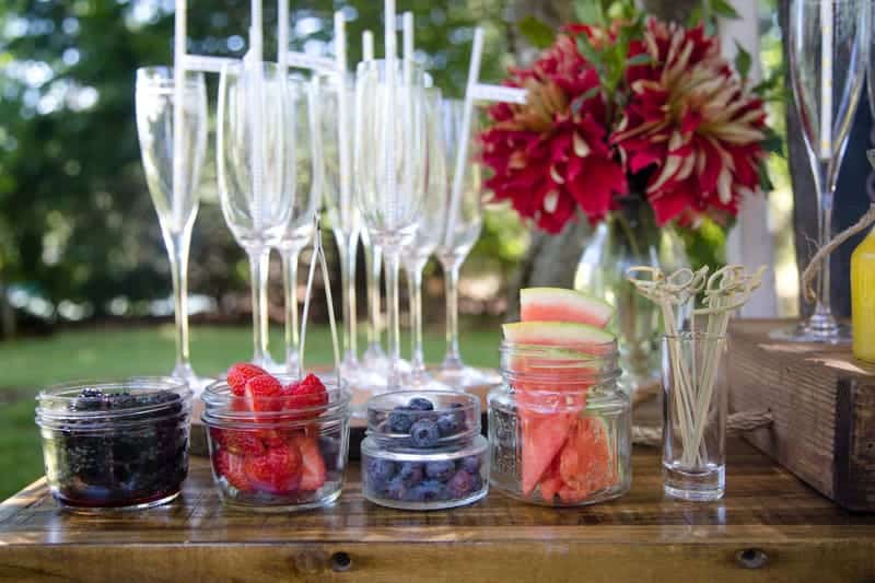 Mimosa Bar with empty glasses and jars of fresh berries