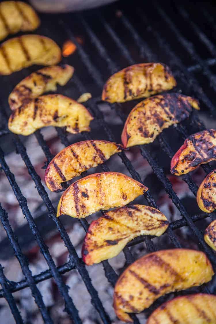 Peach wedges cooking on the grill. 