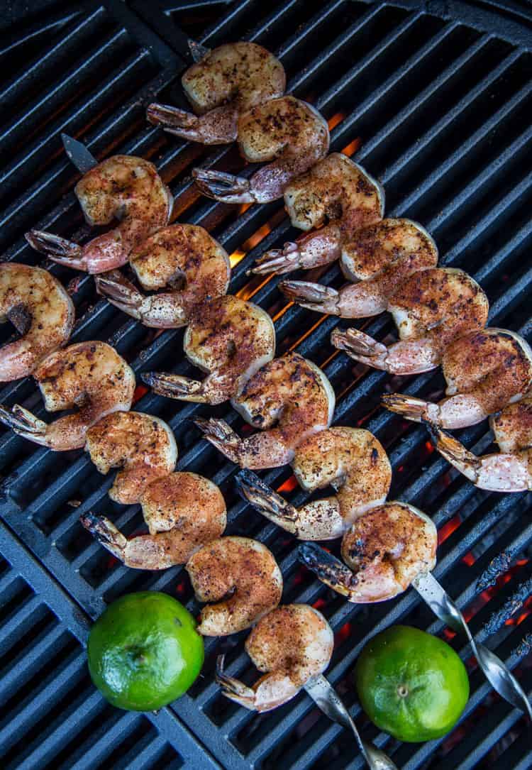 Grilled Shrimp on a skewer over direct heat on a grill grate.