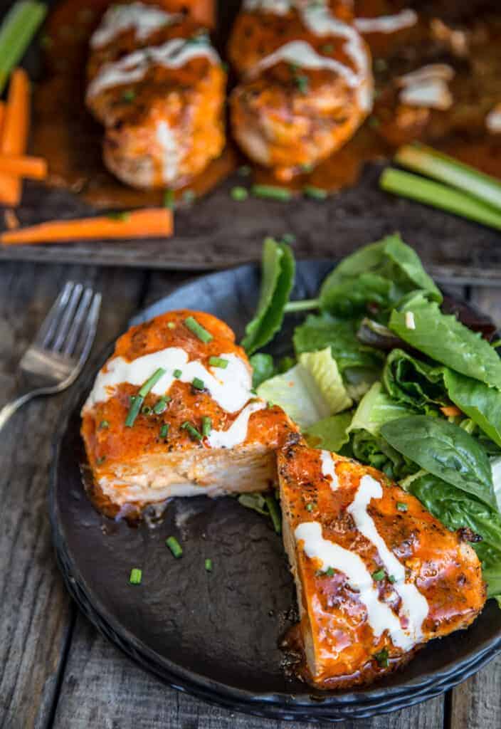 Buffalo Stuffed Chicken Breasts on a plate with salad. 