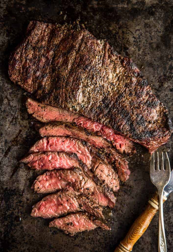 Grilled Bavette Steak sliced thin on a sheet pan. 