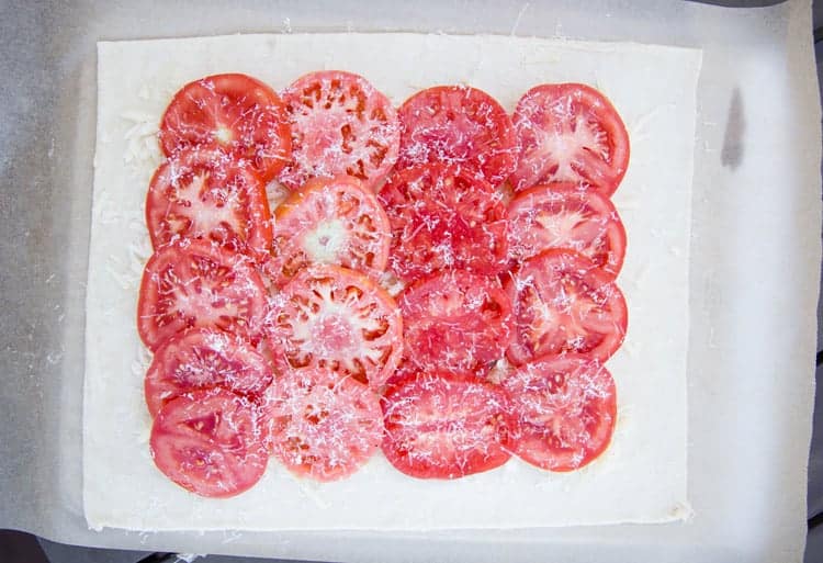 Tomatoes layered on raw puff pastry with Parmesan cheese.