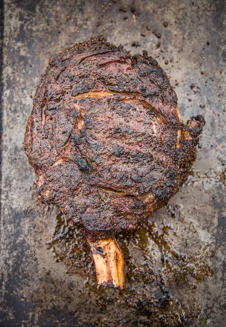 Reverse Seared smoked thick cut cowboy ribeye steak with a coffee ancho dry rub on a sheet pan