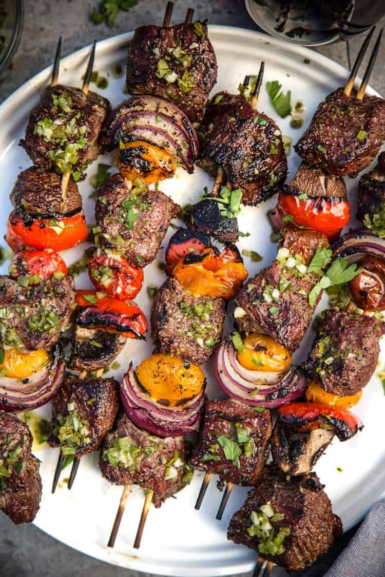 Steak Skewers with Beer Marinade and Jalapeño Parsley Chimichurri sauce on a plate.