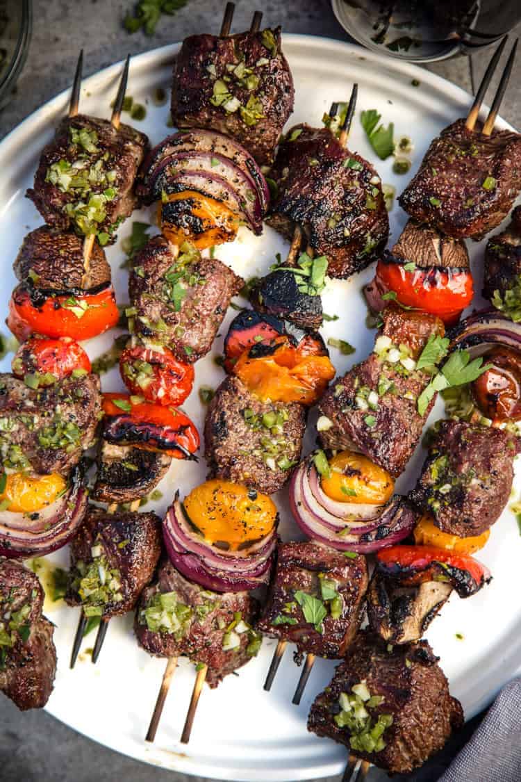 Steak Skewers with Beer Marinade and Jalapeño Parsley Chimichurri sauce on a plate. 