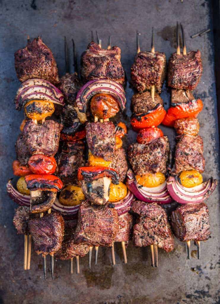 grilled steak skewers with peppers ,tomatoes, onions, and mushrooms on a sheet pan