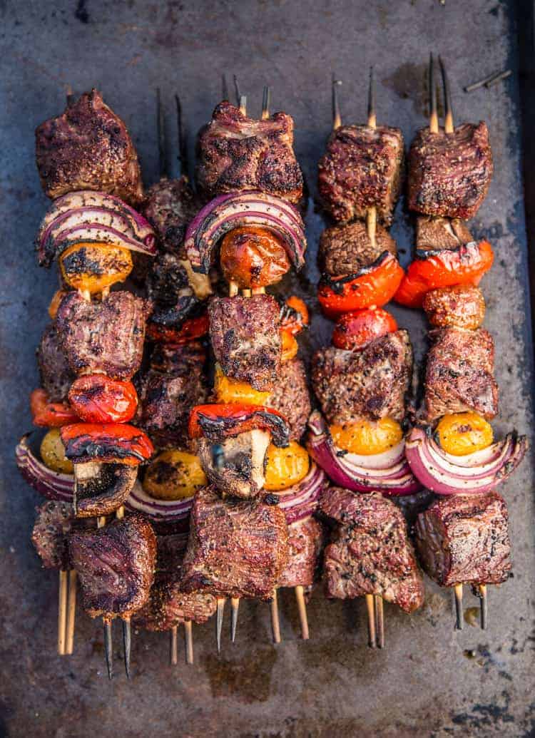 grilled steak skewers with peppers, tomatoes, onions, and mushrooms on a sheet pan