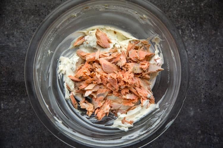 Salmon dip ingredients in a glass bowl before being combined together.