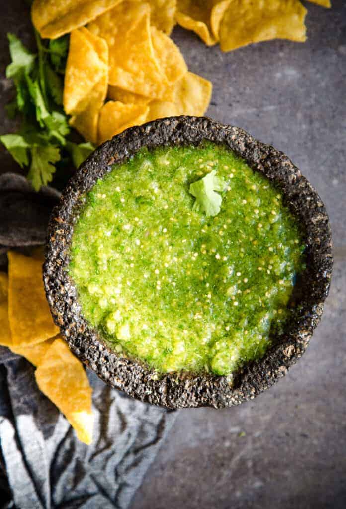 Tomatillo Salsa Verde in a black bowl served with chips