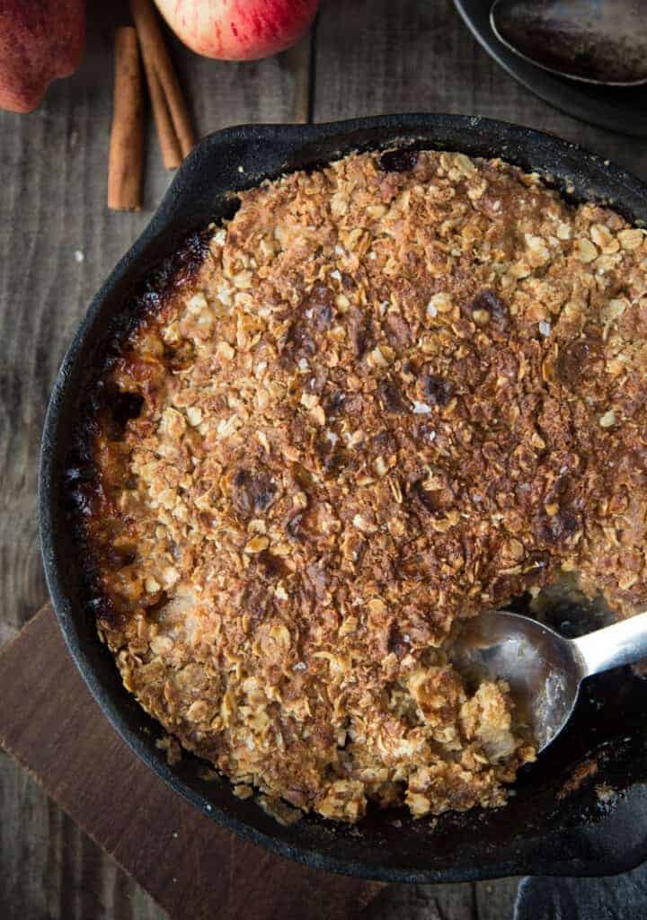 Grilled Apple Crisp in a cast iron with a scoop taken out