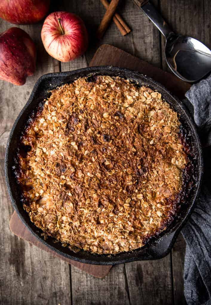 grilled dessert in a cast iron pan with apples and cinnamon to the side