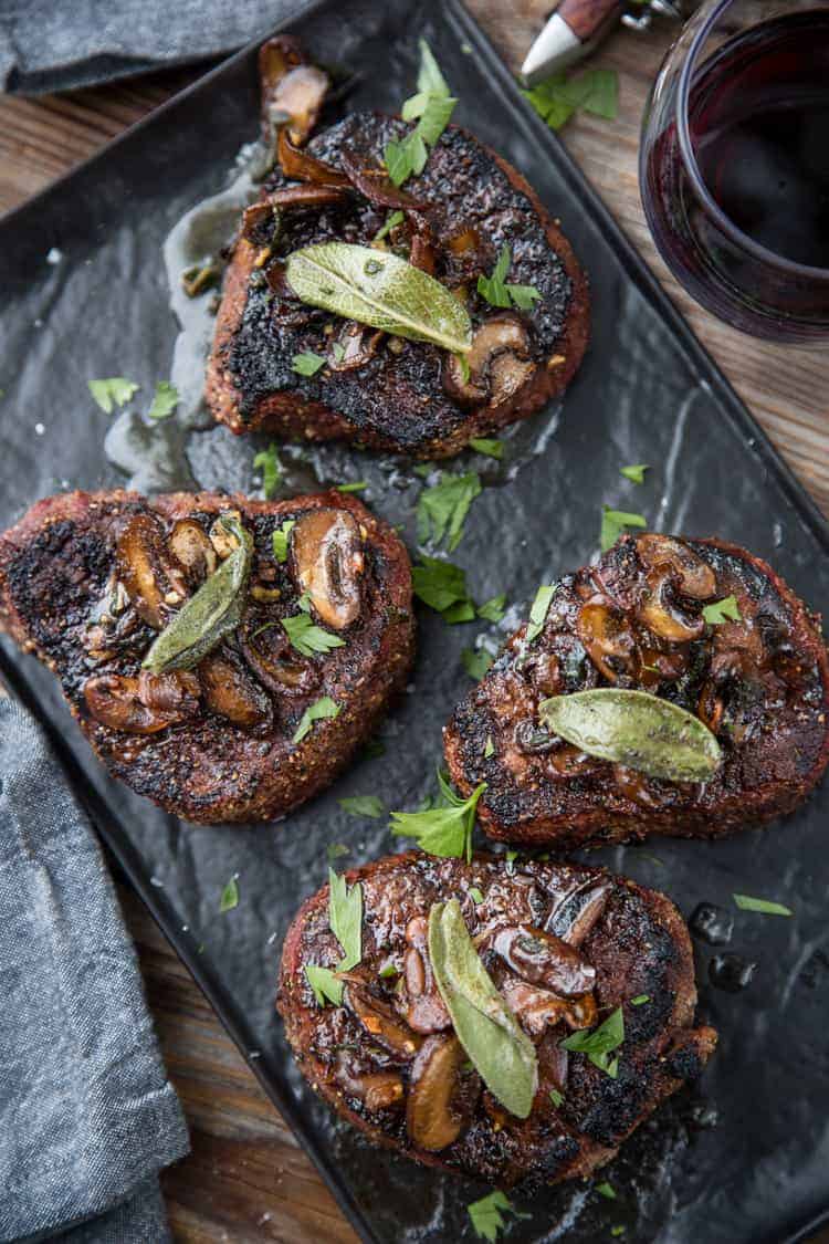 Filet Mignon mustalla lautasella ruskean voin sienikastikkeella ja salvianlehdillä kuorrutettuna