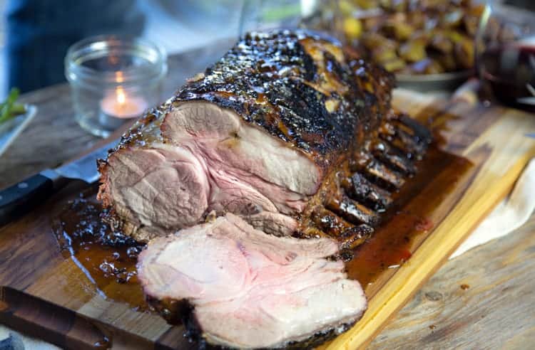 Bone-in pork roast sliced on a cutting board