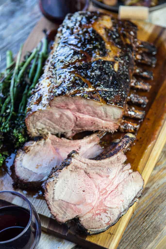 grilled bone-in pork roast with two slices cut on a cutting board