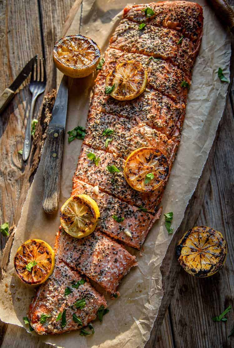 Whole hot smoked salmon filet on a wood board resting