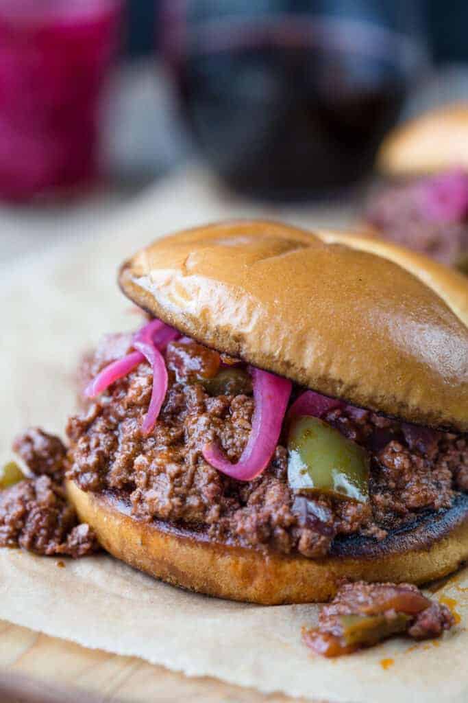 Smoked Sloppy Joe Sandwich on a bun topped with pickled red onions