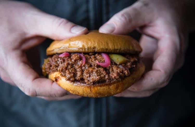 Someone holding a Smoked Sloppy Joe Sandwich