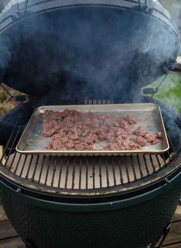 Ground beef cooking on a baking sheet in the smoker