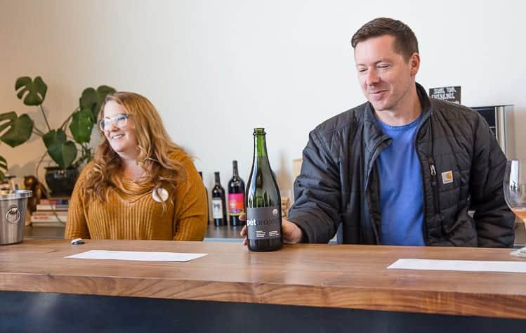 man and woman behind wine bar