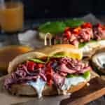 French Dip Sandwiches on a cutting board with homemade au jus sauce