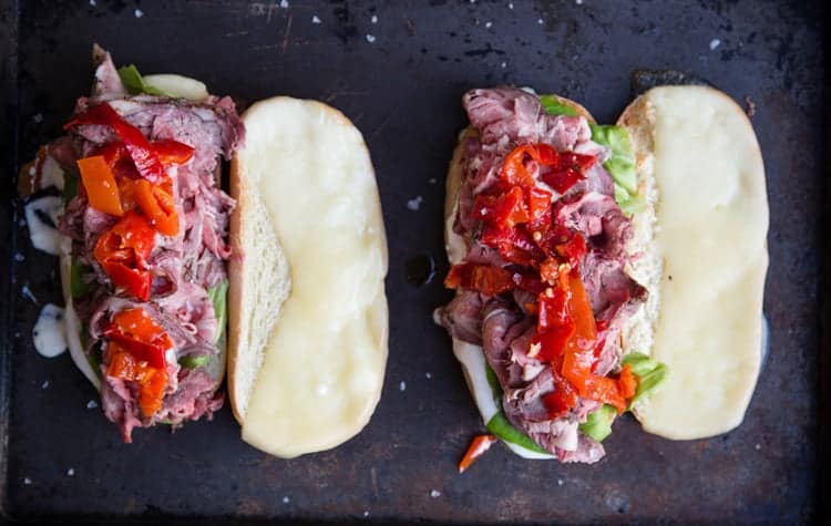 Two French Dip Sandwiches on a platter to go in the oven. 