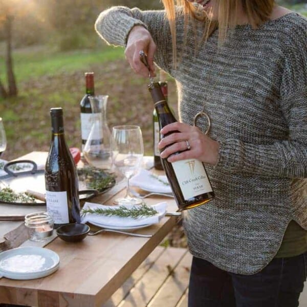 mary cressler opening a bottle of wine