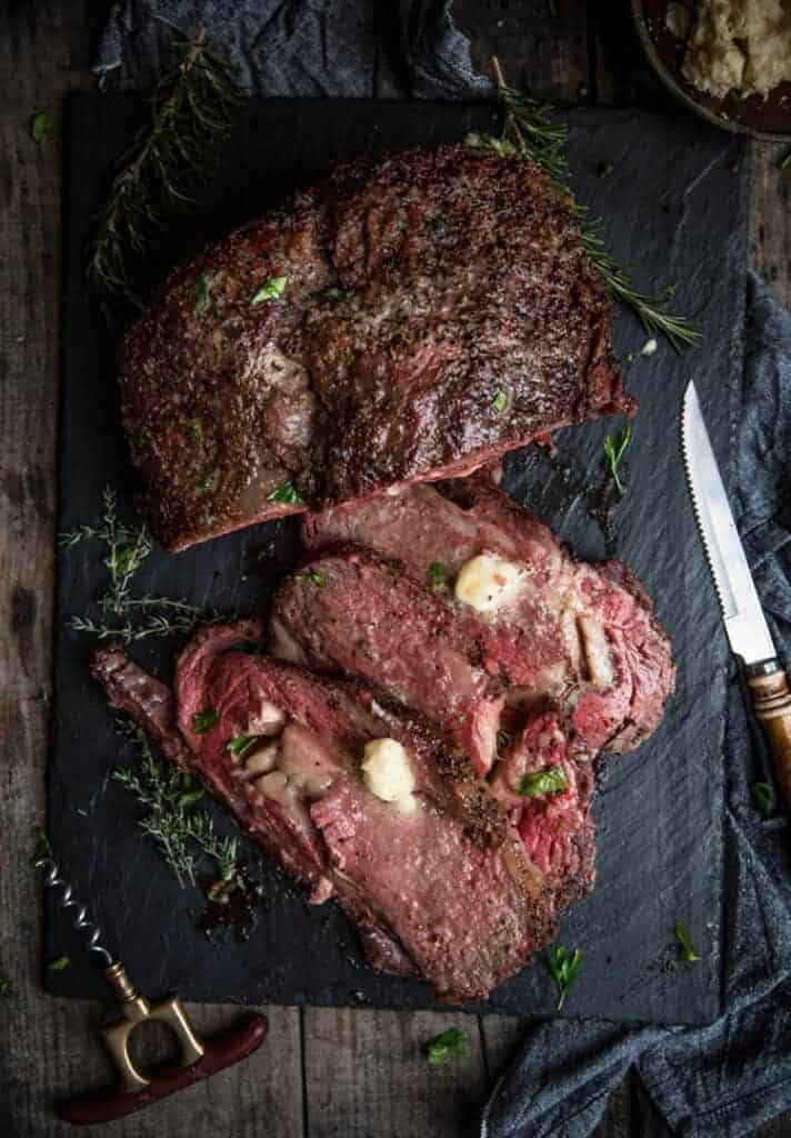 Smoked Prime Rib Roast sliced and topped with butter