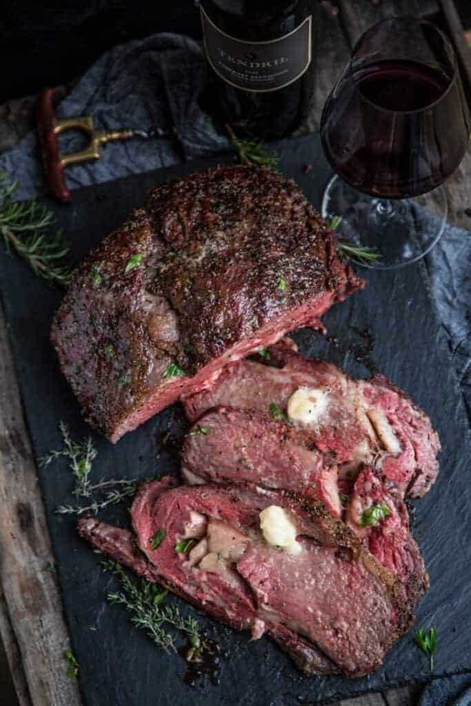 Smoked Prime Rib Roast sliced with horseradish butter and rosemary