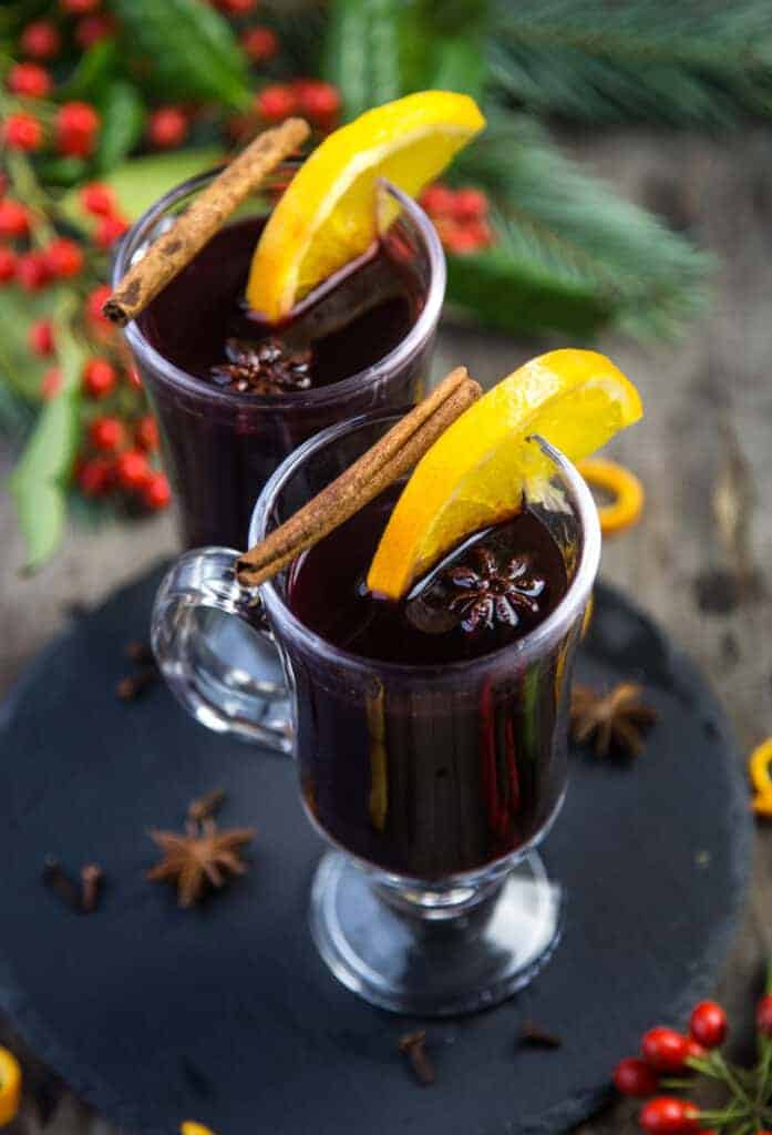 Mulled Wine holiday cocktail in a glass garnished with star anise and orange.