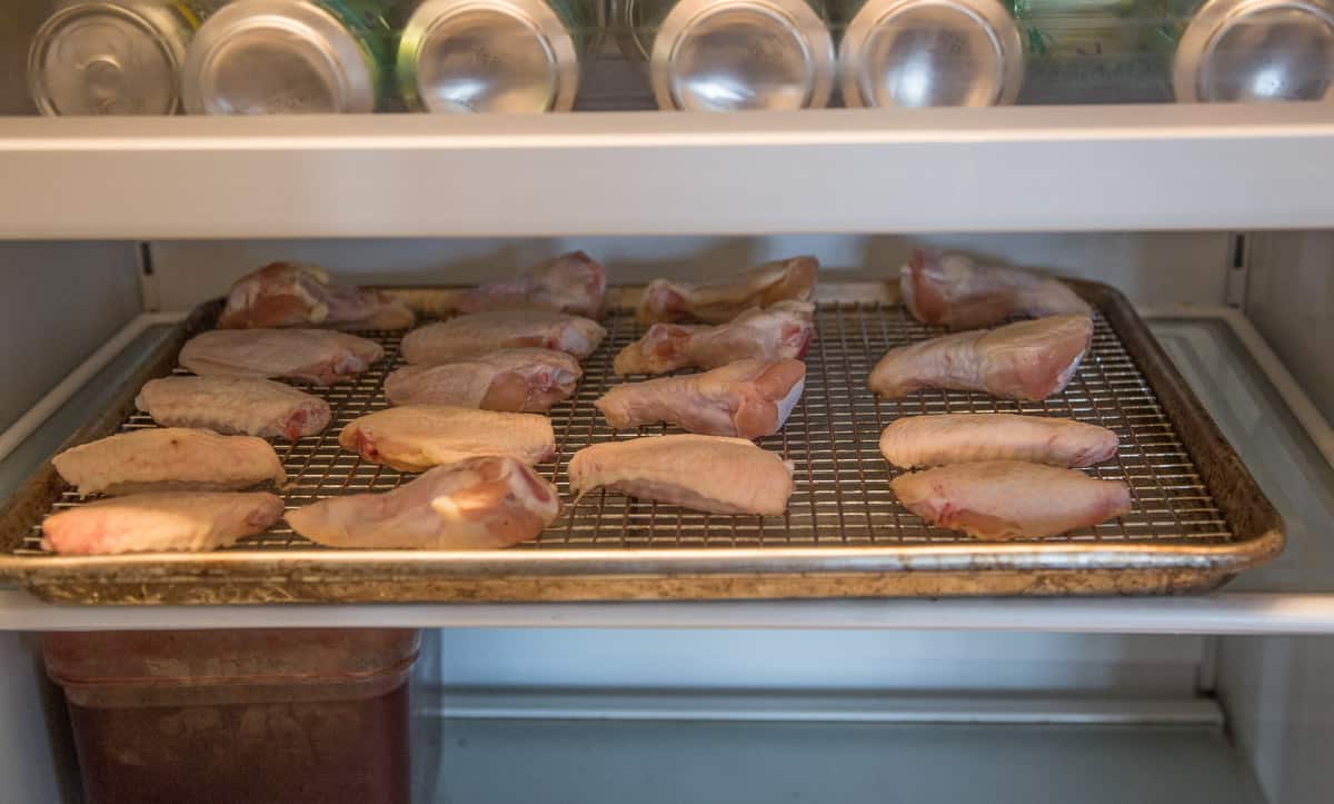 Chicken wings dehydrating in a refrigerator.